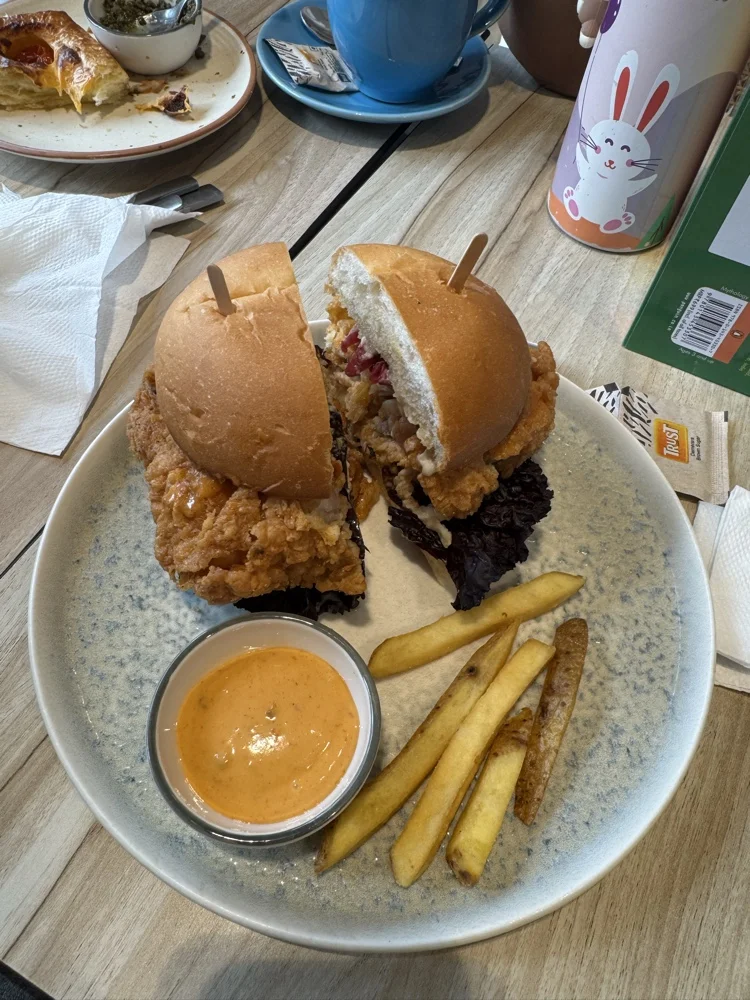 Original unedited burger photo taken with smartphone, showing typical amateur food photography with poor lighting